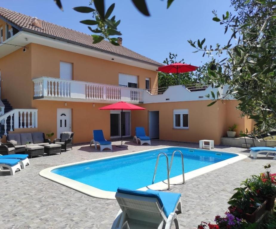 a villa with a swimming pool in front of a house at Apartment Danica in Poličnik