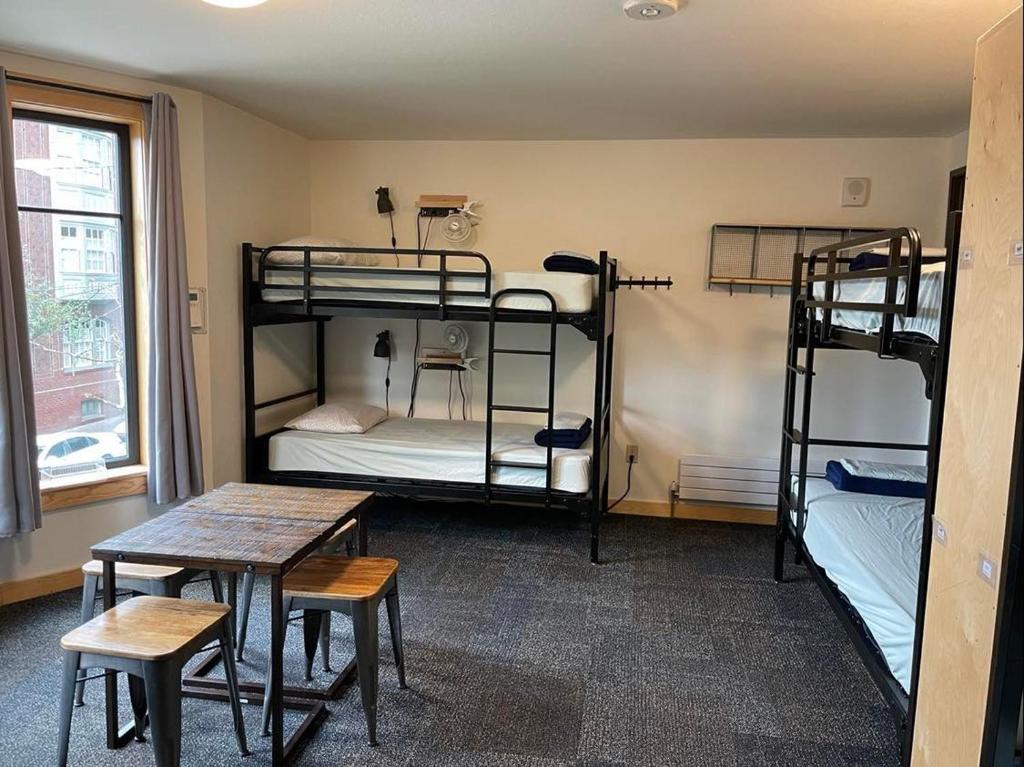 a room with three bunk beds and a table at Northwest Portland Hostel in Portland