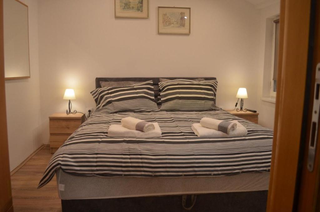 een slaapkamer met een bed met drie kussens erop bij Apartman N&A in Novi Sad