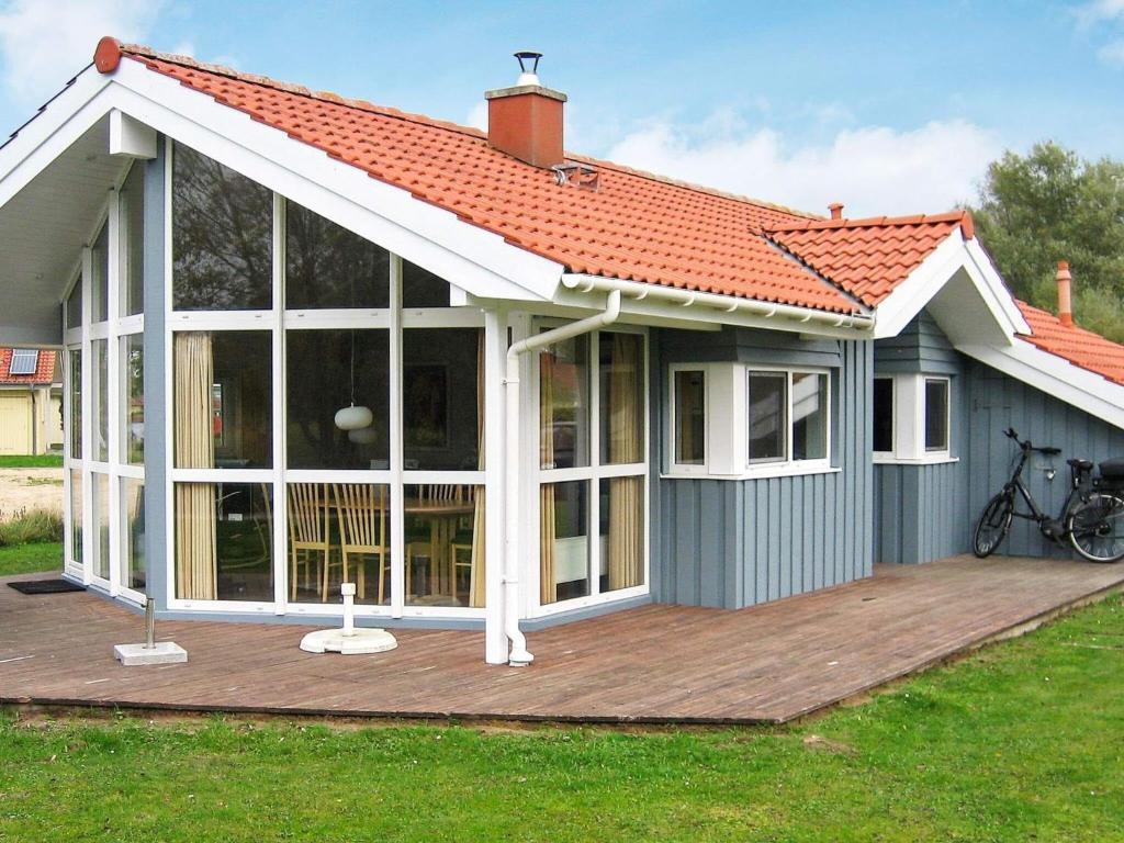 a small house with a deck with a roof at 6 person holiday home in Otterndorf in Otterndorf