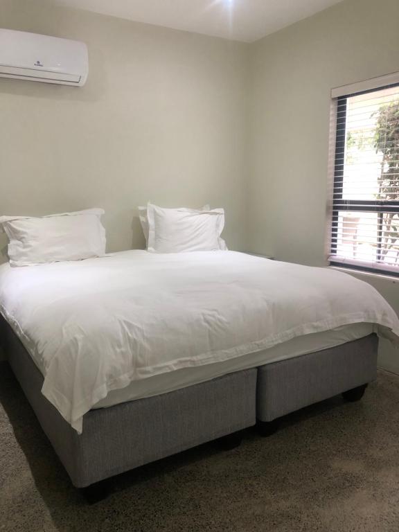 a bedroom with a large bed with white sheets and pillows at 1 The Eighteenth, Prince’s Grant Golf Estate in Blythedale