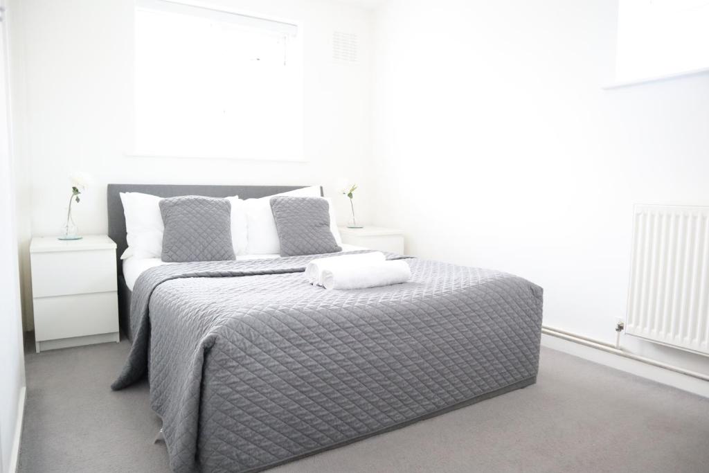 a bedroom with a bed with two pillows on it at Twelve Thirty Serviced Apartments - Balham in London