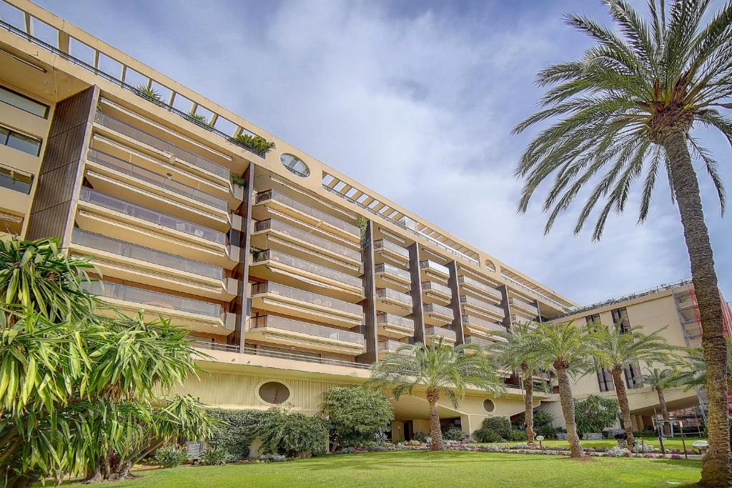 un grand bâtiment avec des palmiers devant dans l'établissement REF 1389 - Cannes Center - Apartment for rent, à Cannes