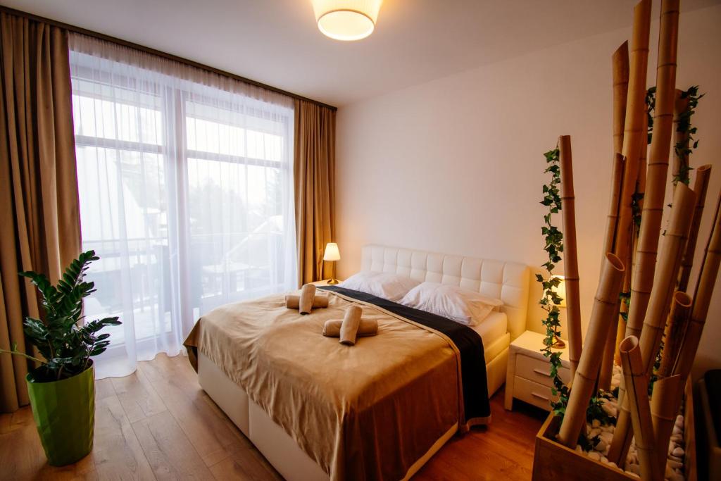 ein Schlafzimmer mit einem Bett und einem großen Fenster in der Unterkunft Apartman Bamboo D107 in Starý Smokovec