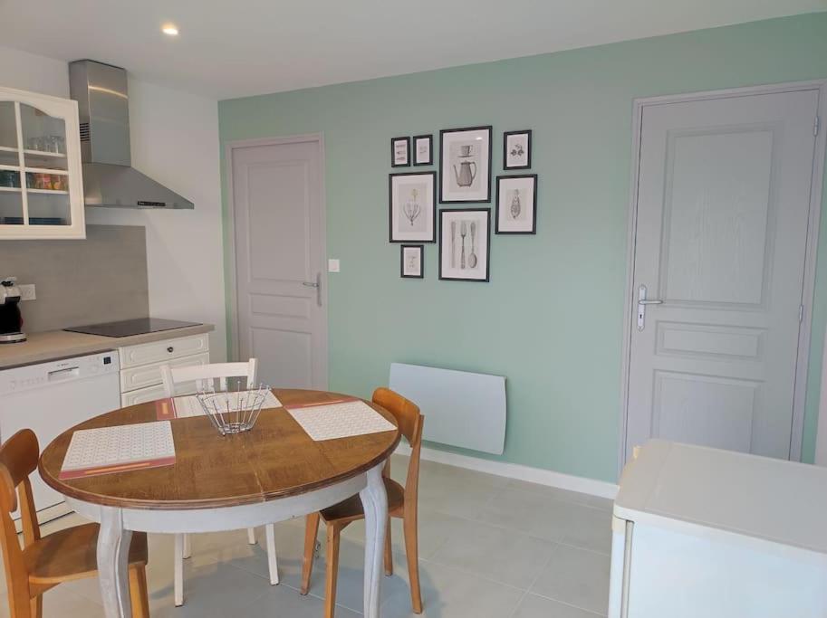 cocina con mesa y sillas en una habitación en Gîte Les Deux Ailes, en Saint-Claude-de-Diray