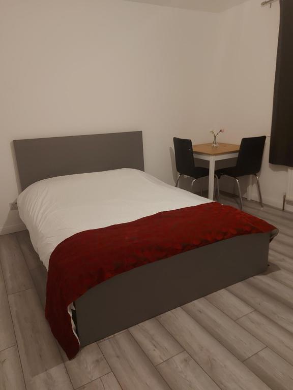 um quarto com uma cama, uma mesa e cadeiras em Aaby House in London em Croydon