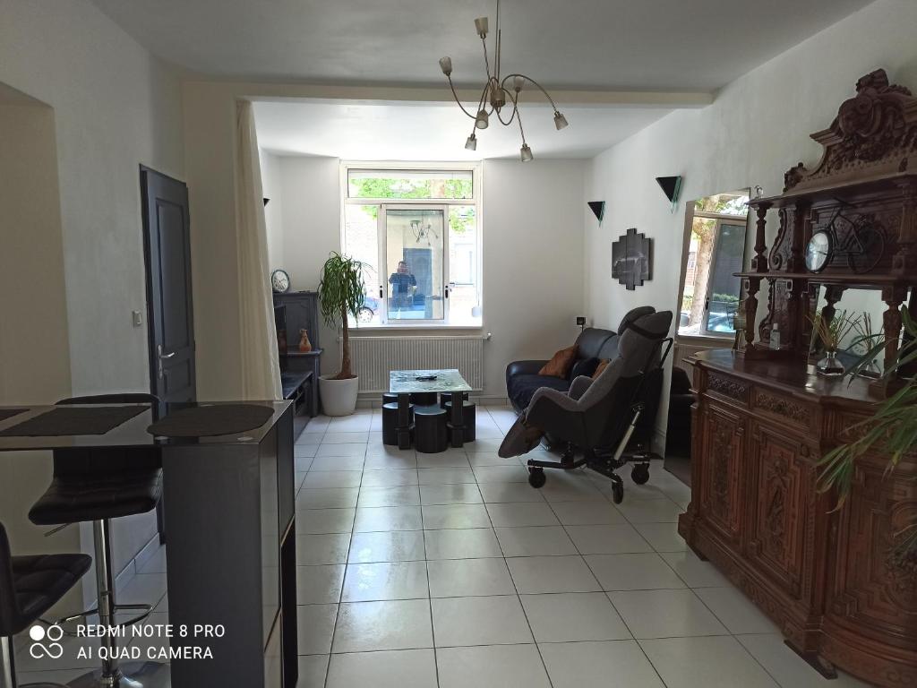 een woonkamer met een stoel en een bureau bij Le franco-belge in Wattrelos