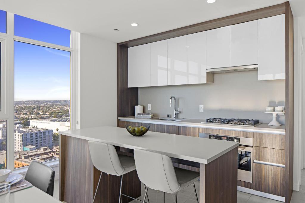 a kitchen with white cabinets and a large window at Level Los Angeles - Downtown Flower in Los Angeles