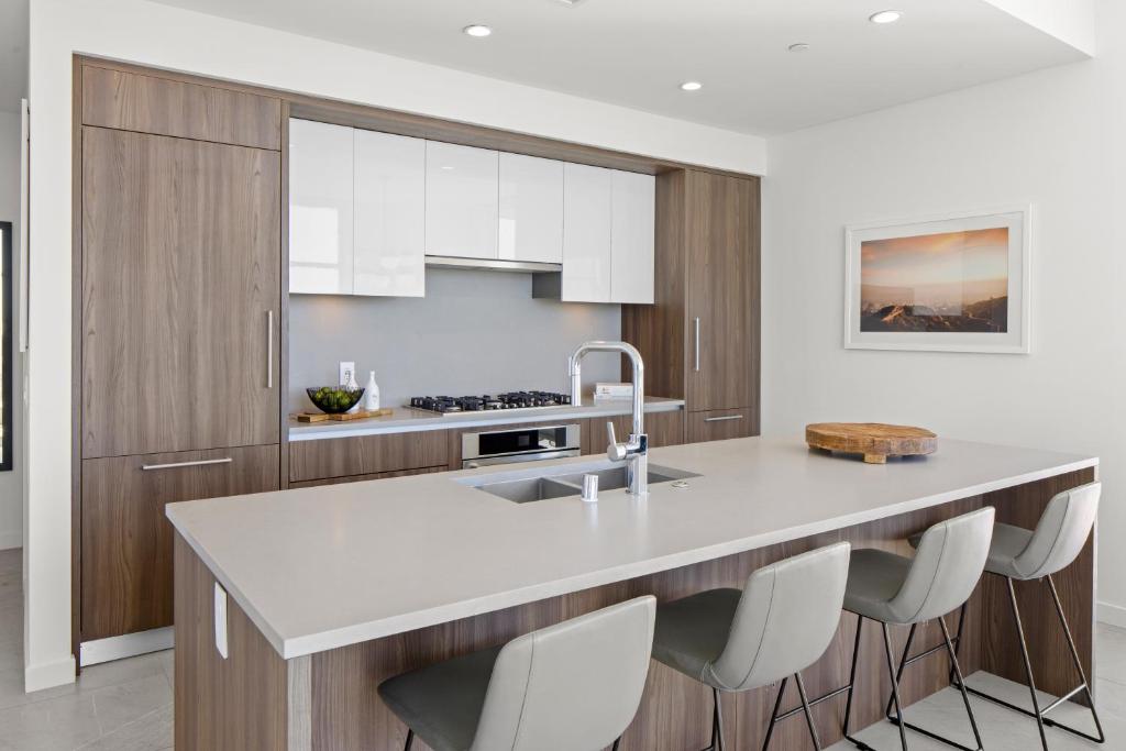 a kitchen with a white counter and wooden cabinets at Level Los Angeles - Downtown Flower in Los Angeles