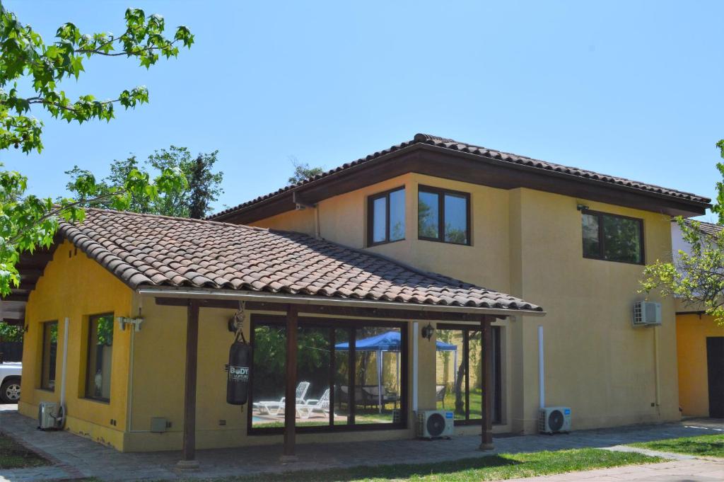 a yellow house with a roof at Olea's Home Las Condes in Santiago