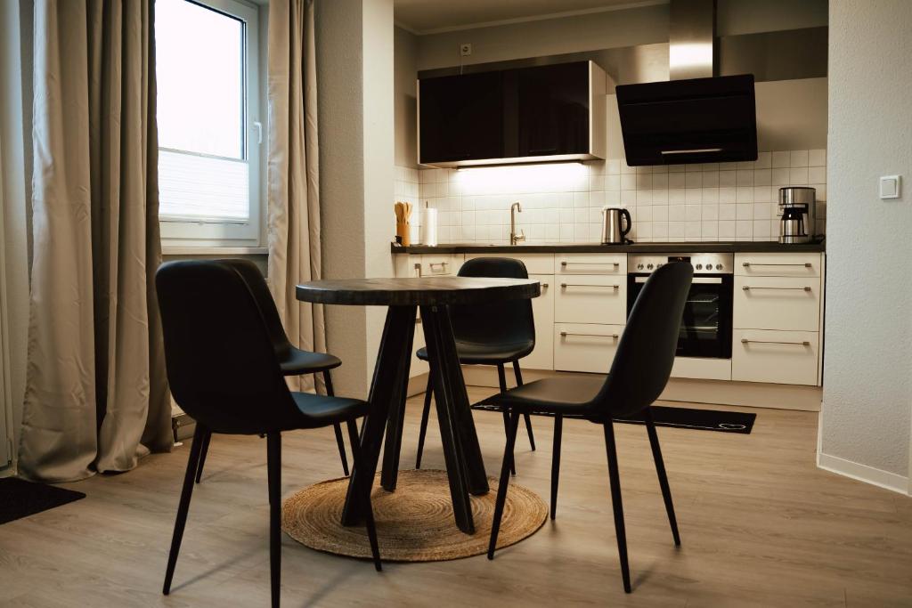 a kitchen with a table and four chairs in it at Ferienwohnung Katharinenberg 