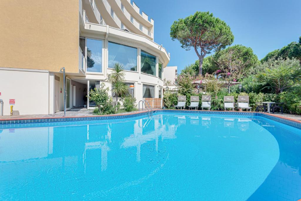 - une piscine en face d'une maison dans l'établissement Hotel Schiller, à Cervia