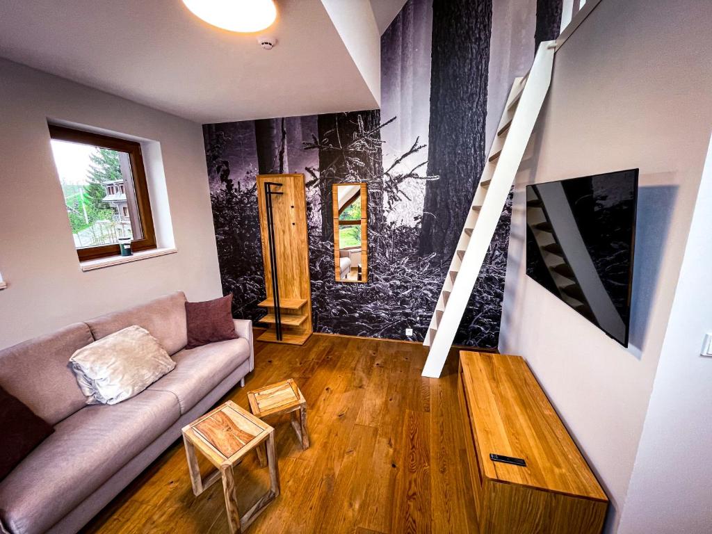 ein Wohnzimmer mit einem Sofa und einer Treppe in der Unterkunft Apartman Bratrouchov in Jablonec nad Jizerou