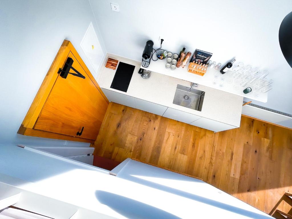 małą kuchnię z białym blatem i drewnianą podłogą w obiekcie Apartman Bratrouchov w mieście Jablonec nad Jizerou