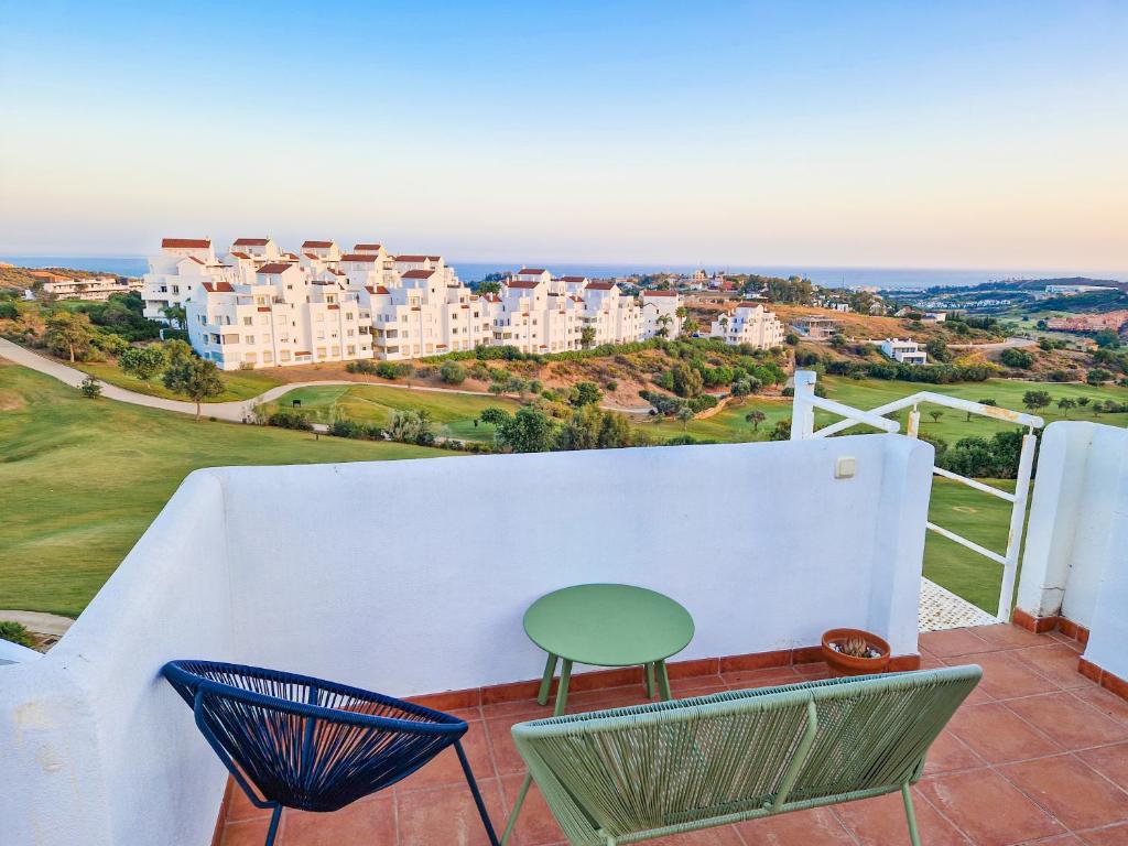 een stoel op een balkon met uitzicht op de gebouwen bij Seaview Penthouse Valle Romano Golf in Estepona