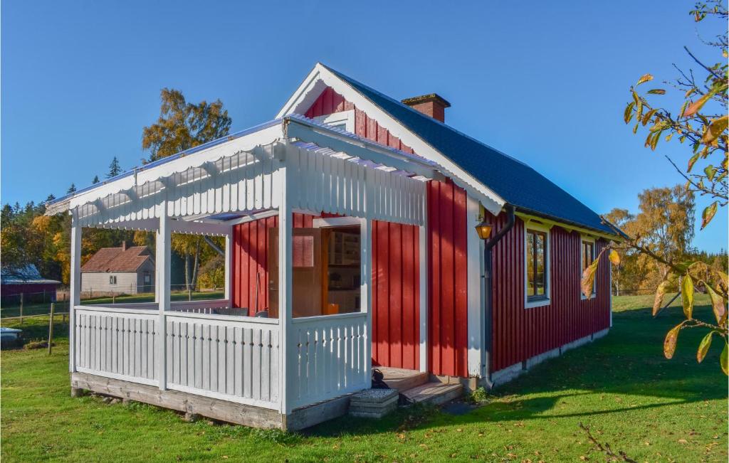 a red and white shed on a grass field at Awesome Home In Kyrkhult With House A Panoramic View in Kyrkhult