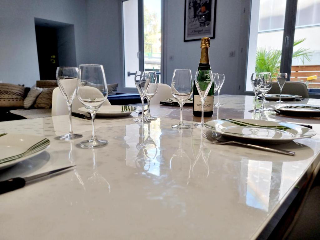 a table with glasses and a bottle of wine at La casa pétillante ! in Ay