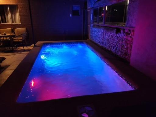 uma piscina com luzes azuis e roxas em Lalck Cketi Hospedaje y Turismo em San Pedro de Atacama