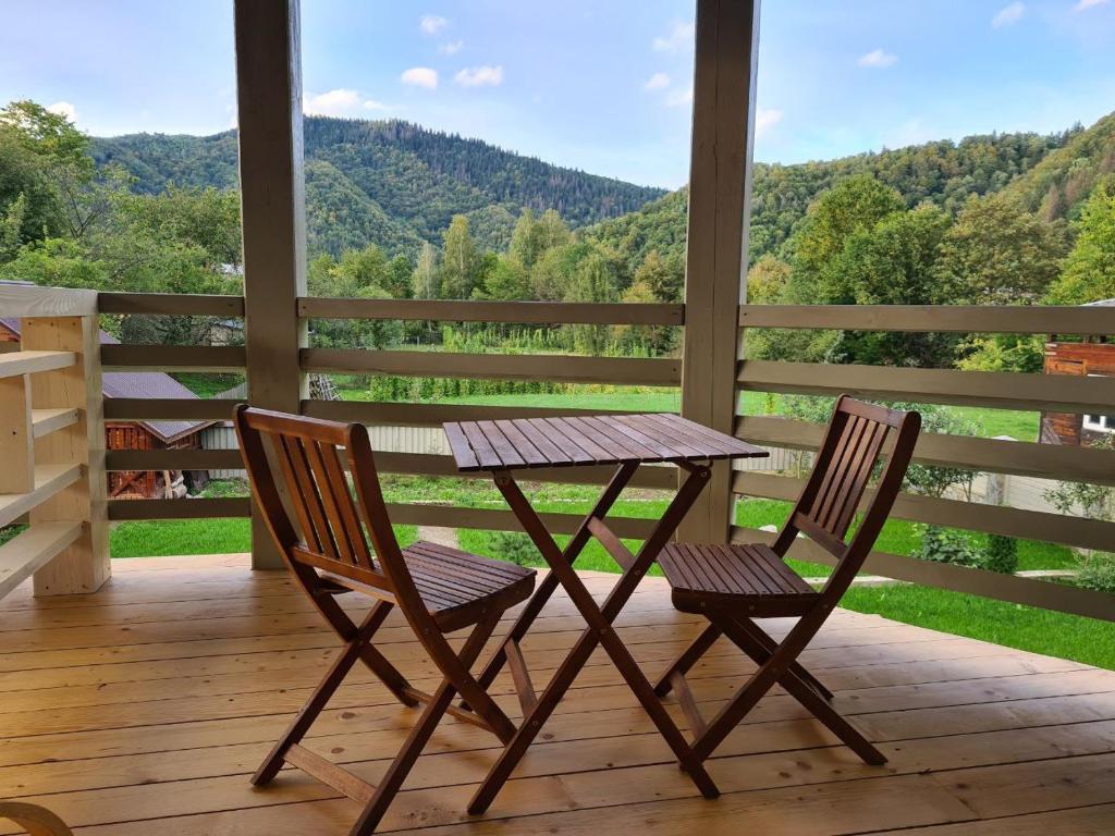 einen Tisch und zwei Stühle auf einer Veranda mit Aussicht in der Unterkunft Апартаменти БАРВА in Beloberëzka