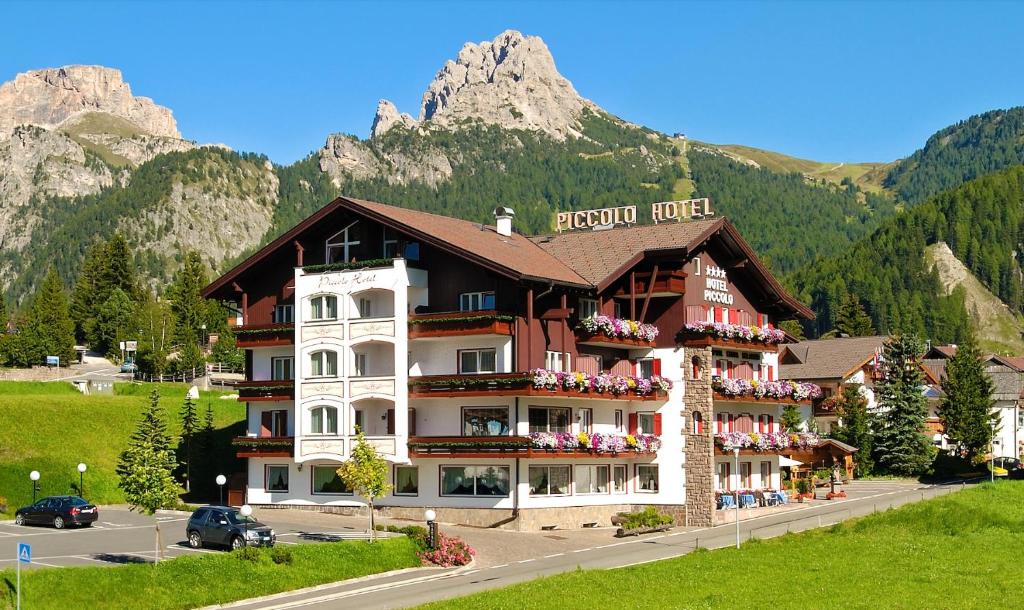ein Hotel in den Bergen mit einem Berg in der Unterkunft Piccolo Hotel in Wolkenstein in Gröden
