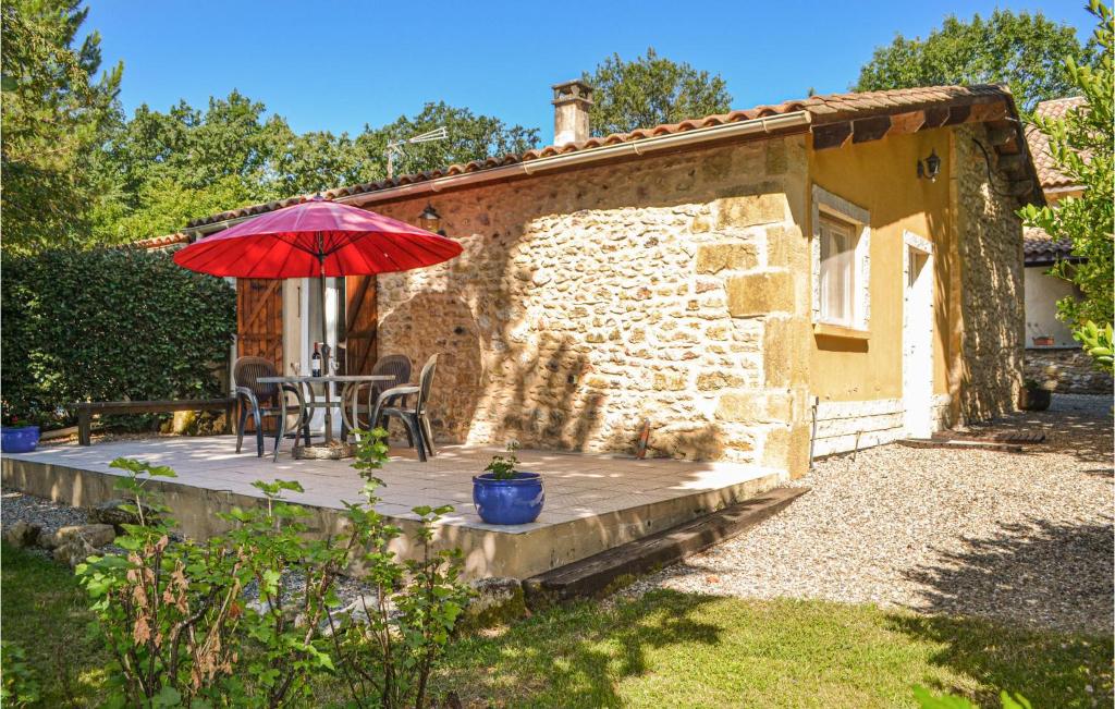 a patio with a red umbrella and a table and chairs at 2 Bedroom Beautiful Home In Lolme in Lolme