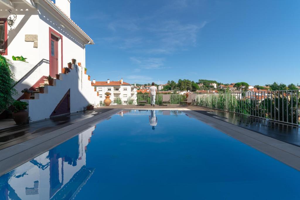 a swimming pool in front of a house at Casa Rural Pucariças - Country & Nature in Proença-a-Nova