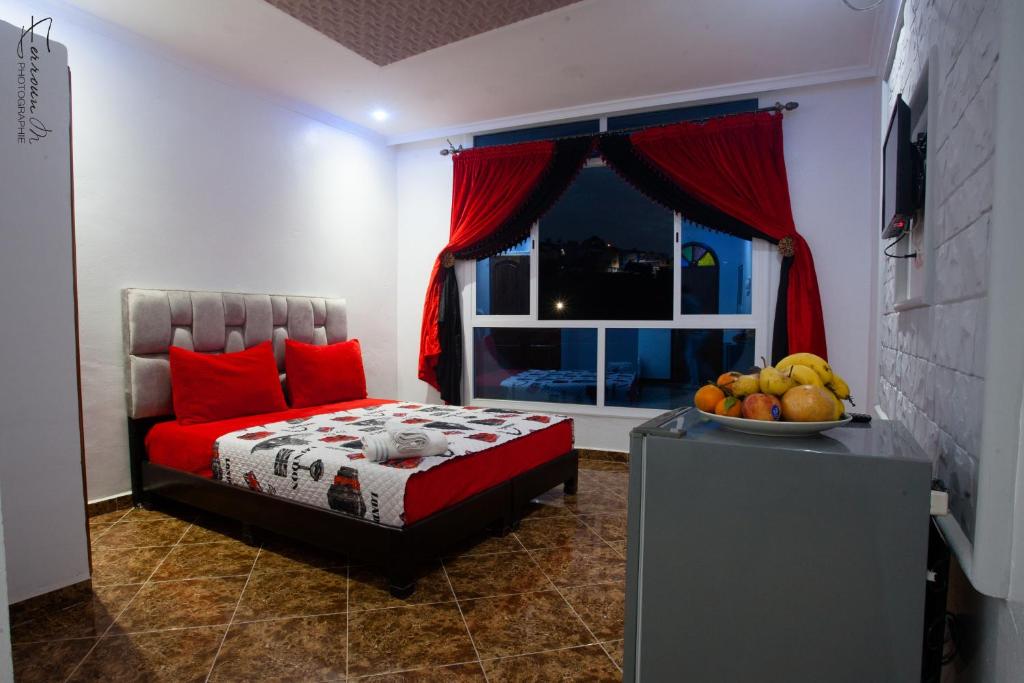 a bedroom with a bed and a window with a bowl of fruit at Dar El Mghouchi in Chefchaouen