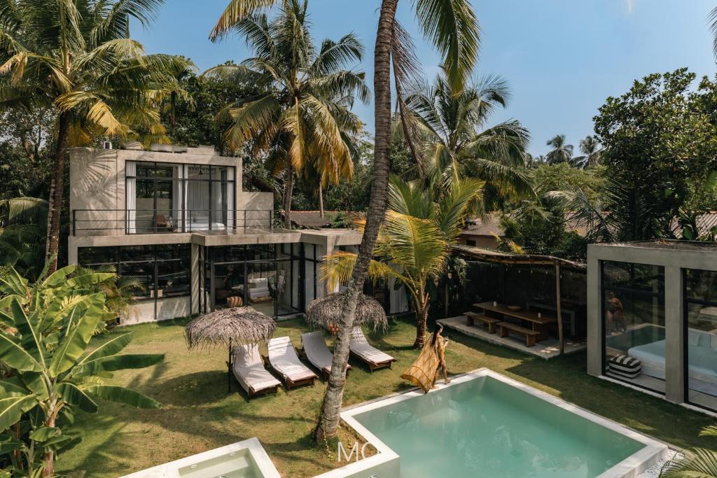zewnętrzny widok na dom z basenem i palmami w obiekcie Tao House Jungle Boutique Villas w mieście Ahangama
