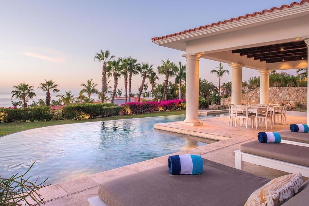 Una piscina en una villa con mesa y sillas. en Stunning 6bd Villa in Palmilla! Fully Staffed w Chauffeur and Yacht included!, en San José del Cabo