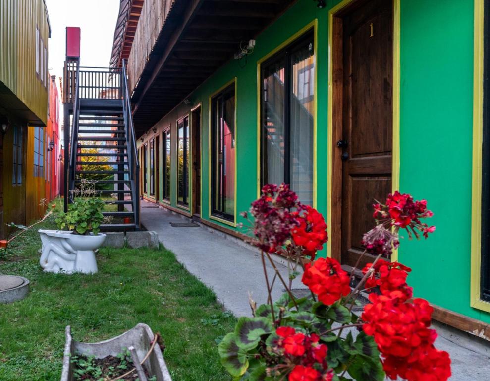 a green building with flowers on the side of it at Kapai Departamentos de Turismo in Valdivia