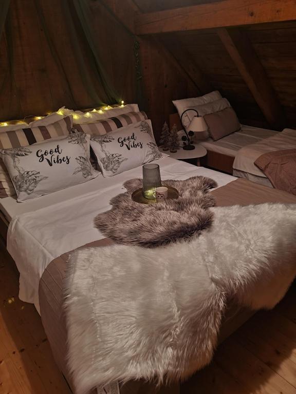 1 Schlafzimmer mit 2 Betten mit weißen Bettdecken und einem Zustellbett in der Unterkunft Vikendica Pahuljica in Risovac