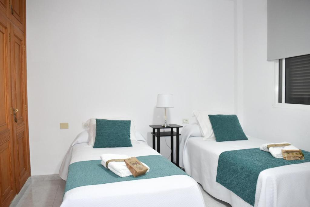a room with two beds with towels on them at apartamento sabare rambla in Frontera