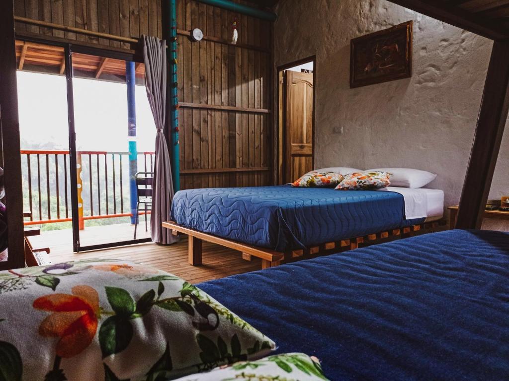 a bedroom with two beds and a balcony at Jaibaná Spa in Támesis