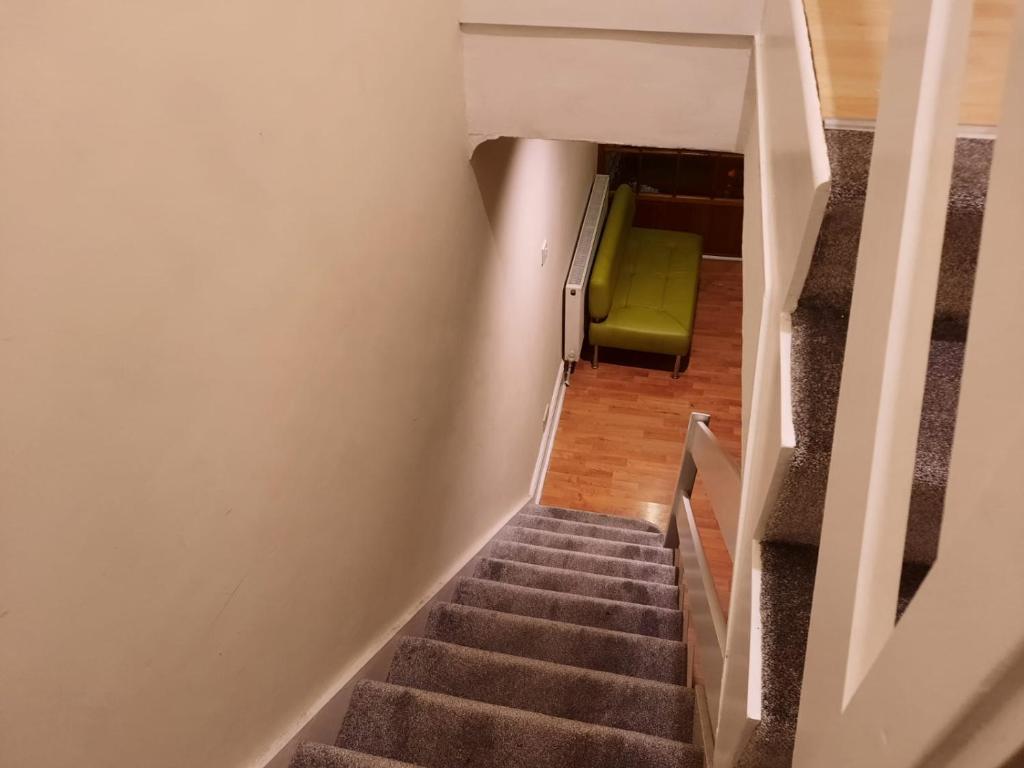 een trap met een groene stoel in een kamer bij Relevant properties in Welling