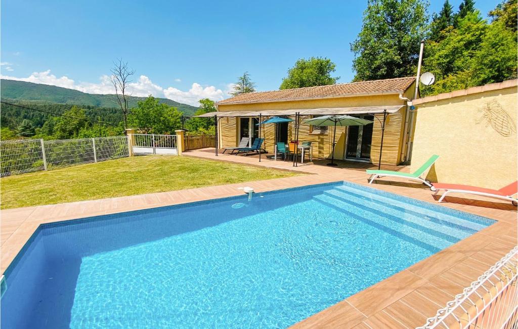 a blue swimming pool in front of a house at Stunning Home In Molires-sur-cze With Wifi in Molières-sur-Cèze