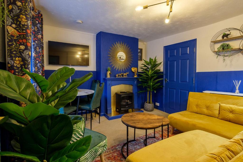 a living room with blue walls and a yellow couch at Stay in the heart of Isle of Wight in 2BDR apt in Newport