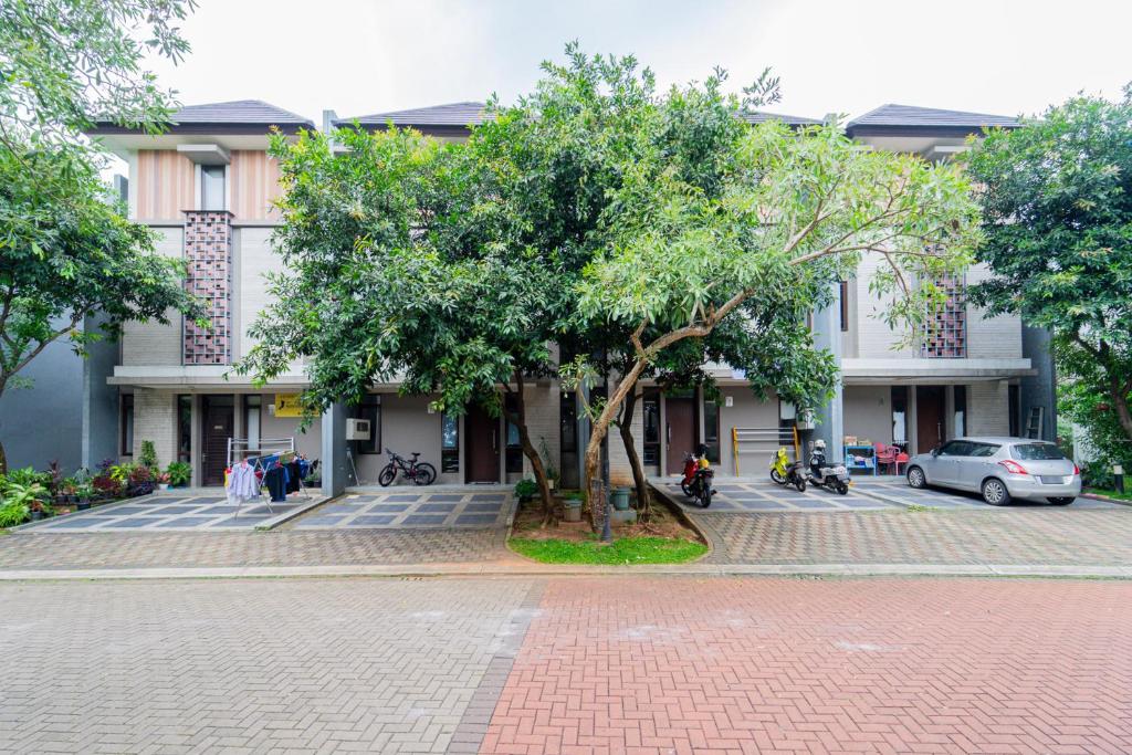 a building with a tree in the middle of a street at Apik Kamila BSD in Tjilandak