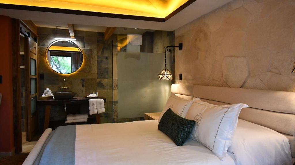 a bedroom with a white bed and a mirror at Hotel Boutique Casa Laja in San Miguel de Allende