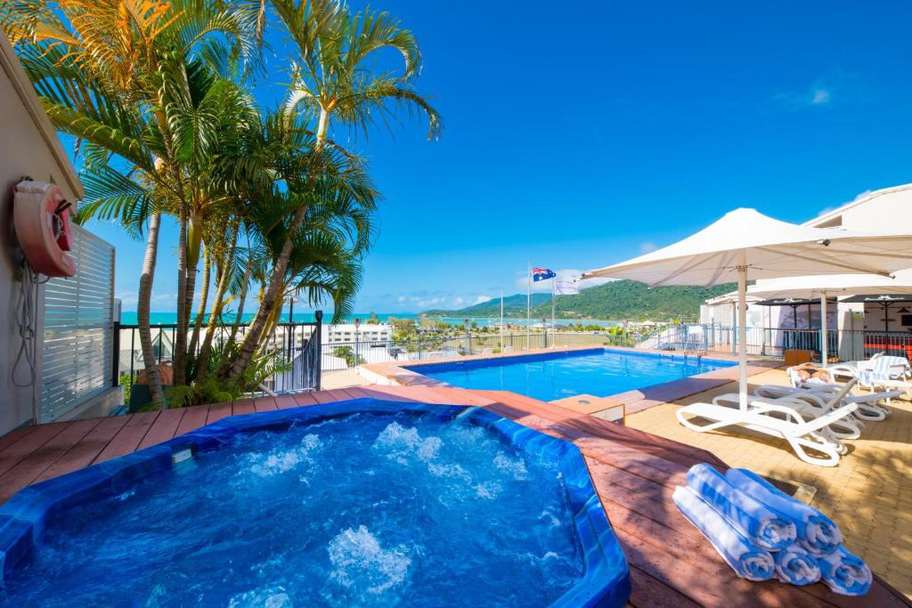 a swimming pool with a view of a resort at Ocean Views at Whitsunday Terraces Resort in Airlie Beach