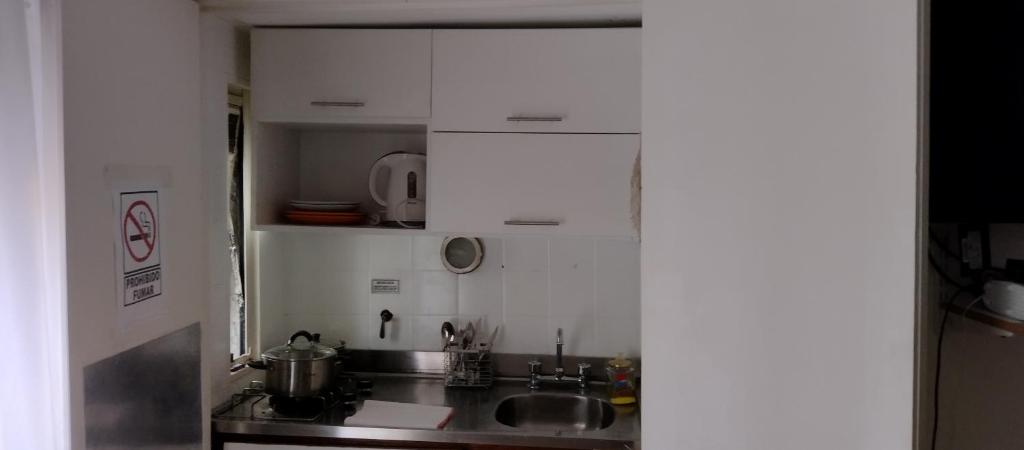 una cocina con armarios blancos y fregadero en Departamento en Congreso en Buenos Aires
