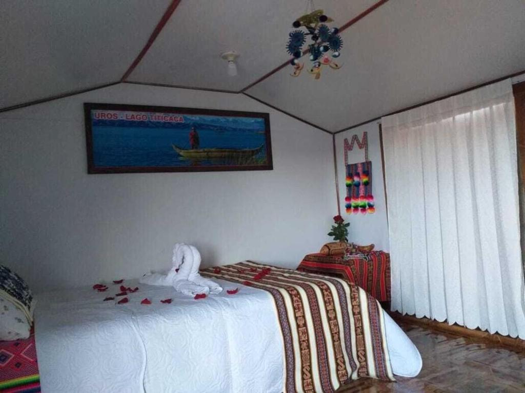 1 dormitorio con 1 cama y una pintura en la pared en TITICACA WORLDWIDE LODGE, en Puno