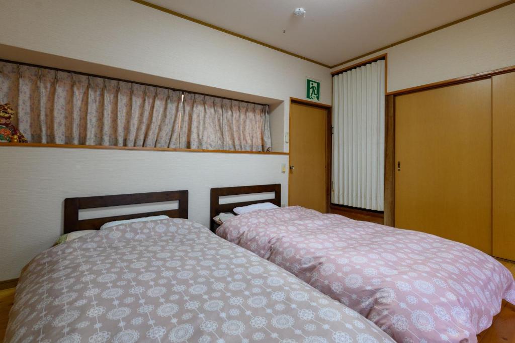 宇和島市にあるすなだの家のベッドルーム1室(隣り合わせのベッド2台付)