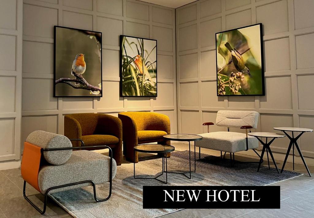 um quarto com cadeiras e mesas e pinturas na parede em Le Vert Boutique Hotel em Genting Highlands