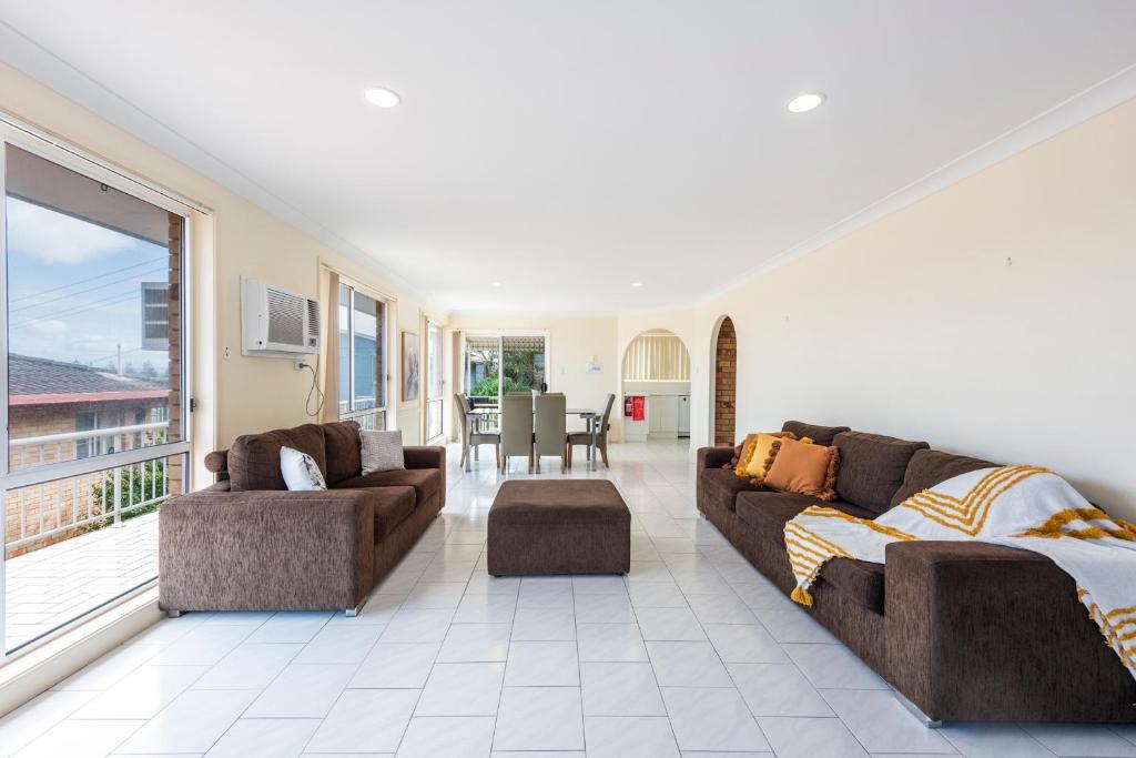 a living room with two couches and a large window at 1 6 Convent Lane-LJHooker Yamba in Yamba