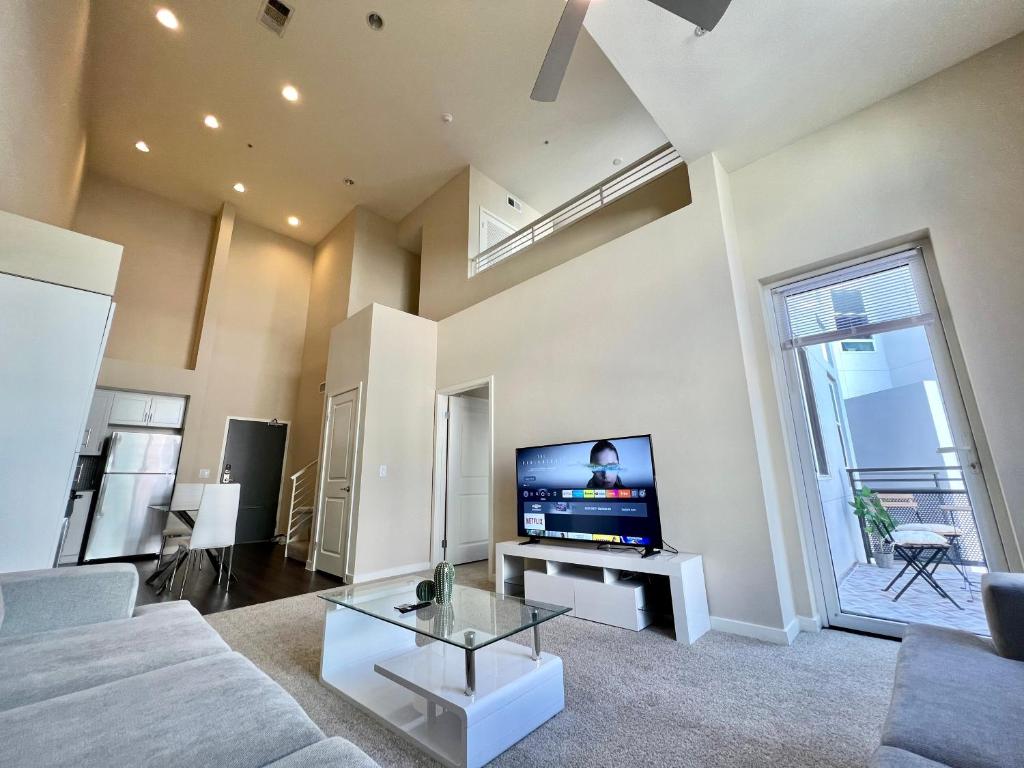 Luxury Residence Loft 3 Beds with Pool and Gym في لوس أنجلوس: غرفة معيشة مع أريكة وتلفزيون