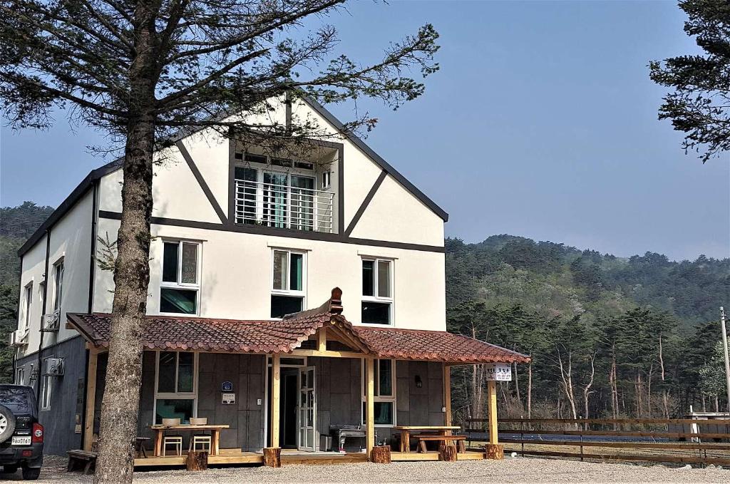 un gran edificio blanco con un árbol delante en Odaesan Moonlight en Pyeongchang 