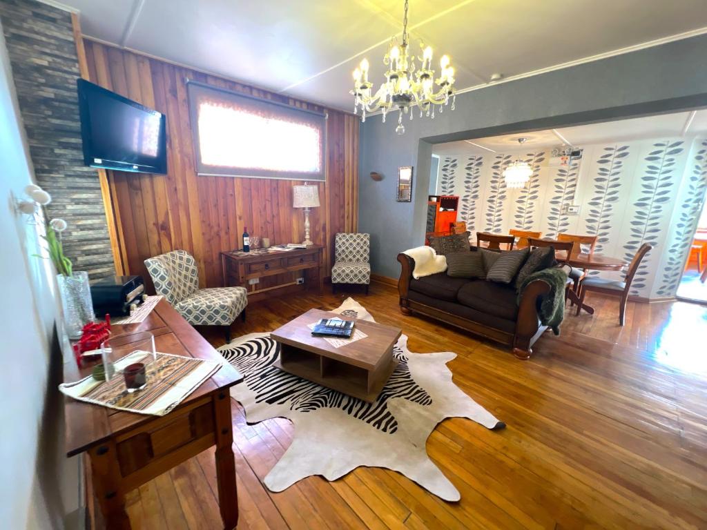 uma sala de estar com um sofá e uma mesa em Incredible Downtown Duplex with Interior Backyard em Punta Arenas