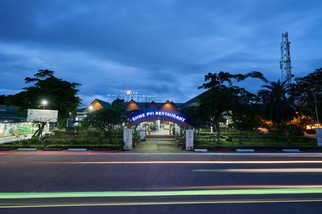 un edificio con una señal azul en el lateral de una calle en KMA 115 MILES Hotel, en Pyu