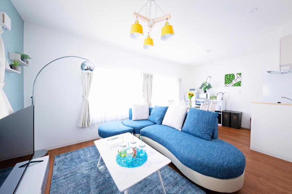 sala de estar con sofá azul y mesa en APHONGO HOTEL, en Tsukisappu