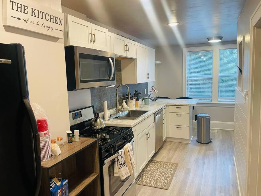 a kitchen with white cabinets and a stove top oven at Modern Farmhouse on Kent Street in Saint Paul